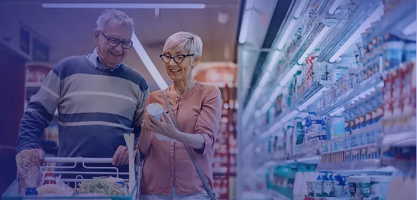 Older shoppers choosing fresh groceries in a supermarket aisle